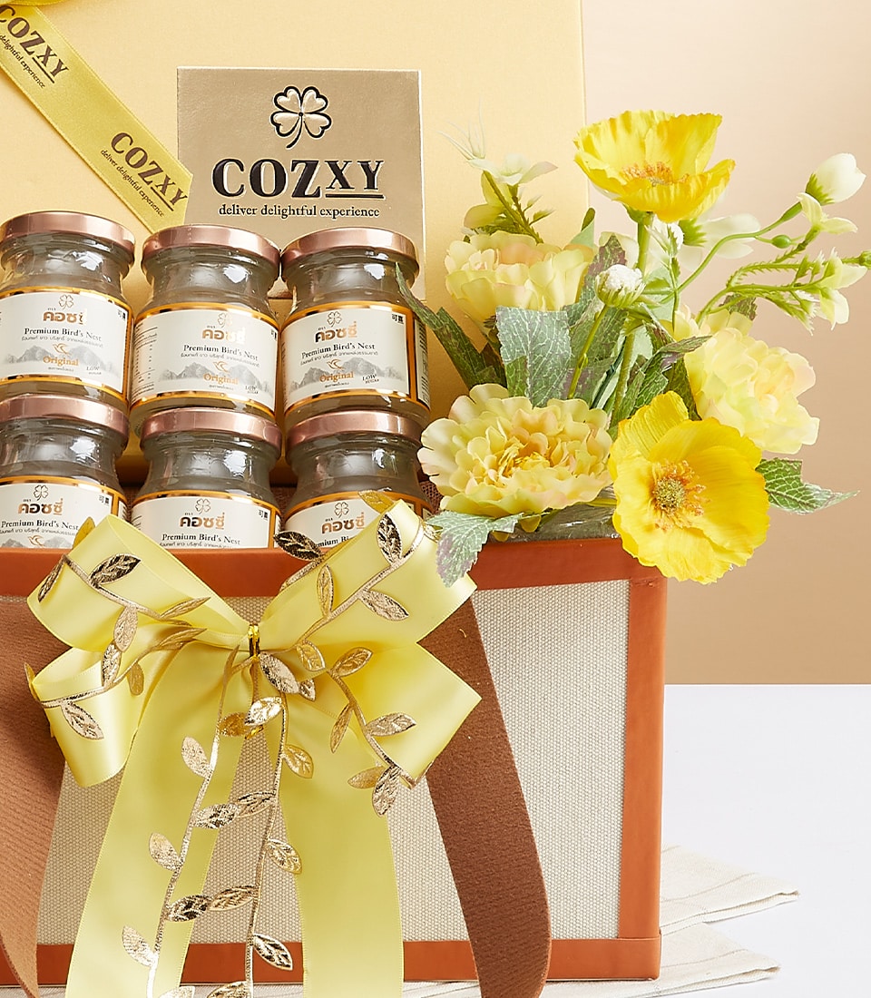 Opulent Cozzy's Premium Bird's Nest gift set with six rose gold-lidded jars, yellow ribbon bow, and artificial yellow flowers