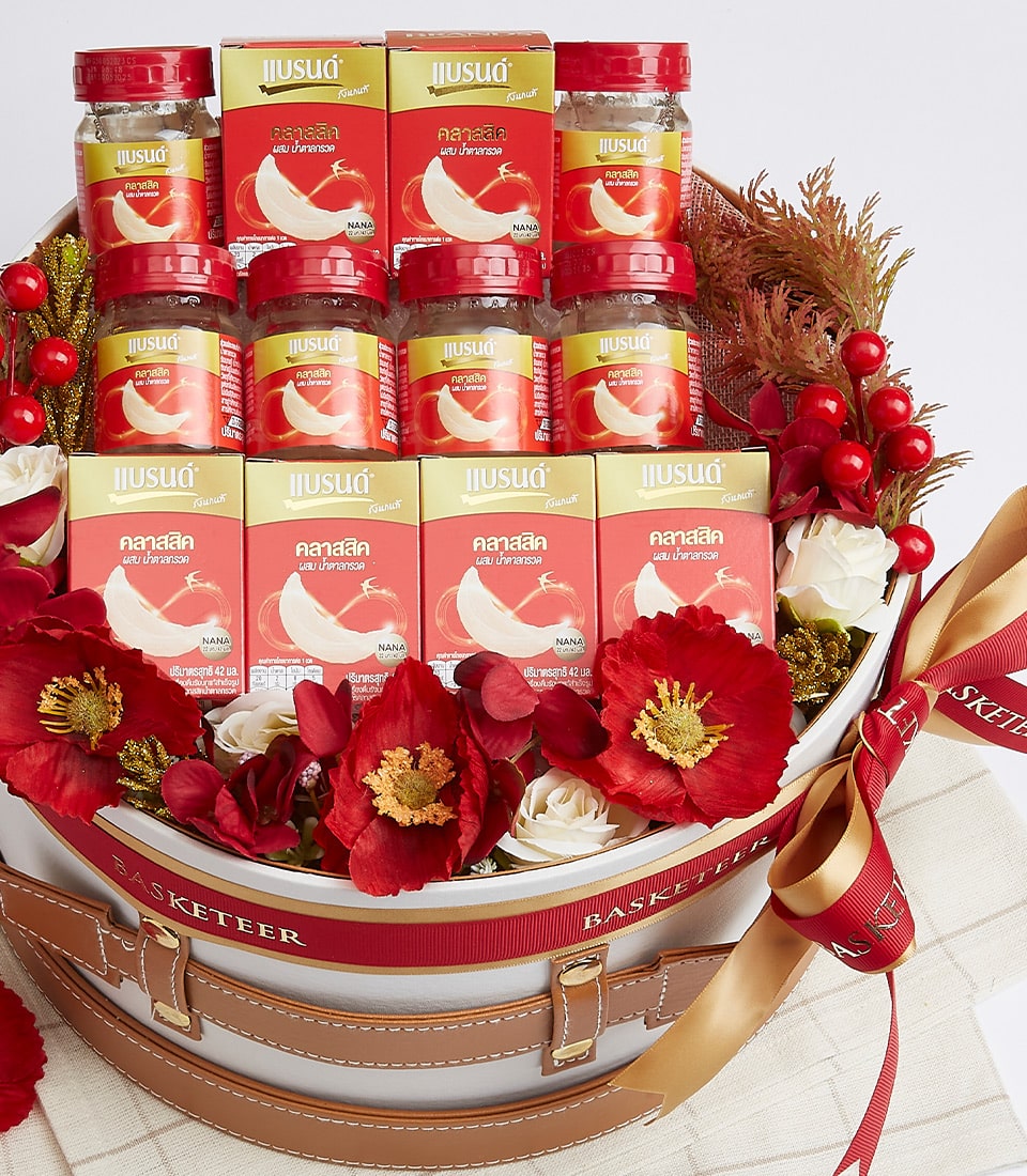 Premium bird's nest gift basket with red and gold accents, glass jars and boxes in vintage wicker case with leather handles