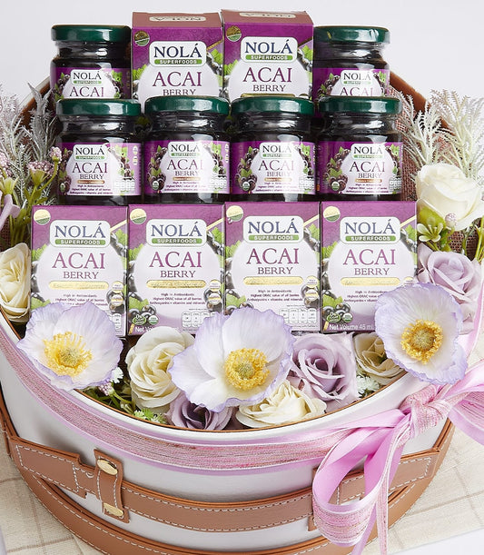 Nola Acai Berry superfood gift basket with glass jars and boxes in white round container with brown handles and pink ribbon