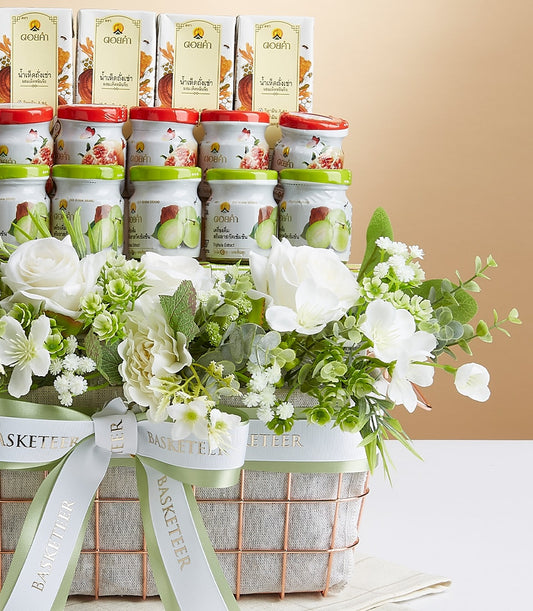 Elevated Doi Kham mixed wellness gift basket with rose gold mesh, white and green floral accents, premium Thai health