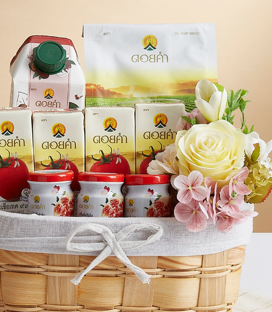 Woven gift basket with Doi Kham wellness products, white packaging, red-lid jars, and cream roses