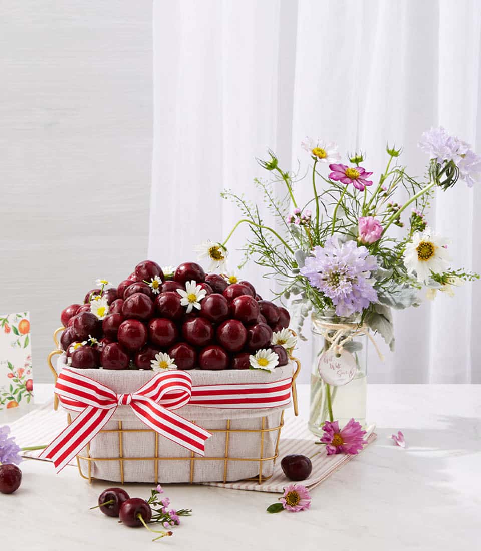 Cherry blossom gift basket with fresh dark red cherries, white daisies, and wildflower bouquet for get well wishes