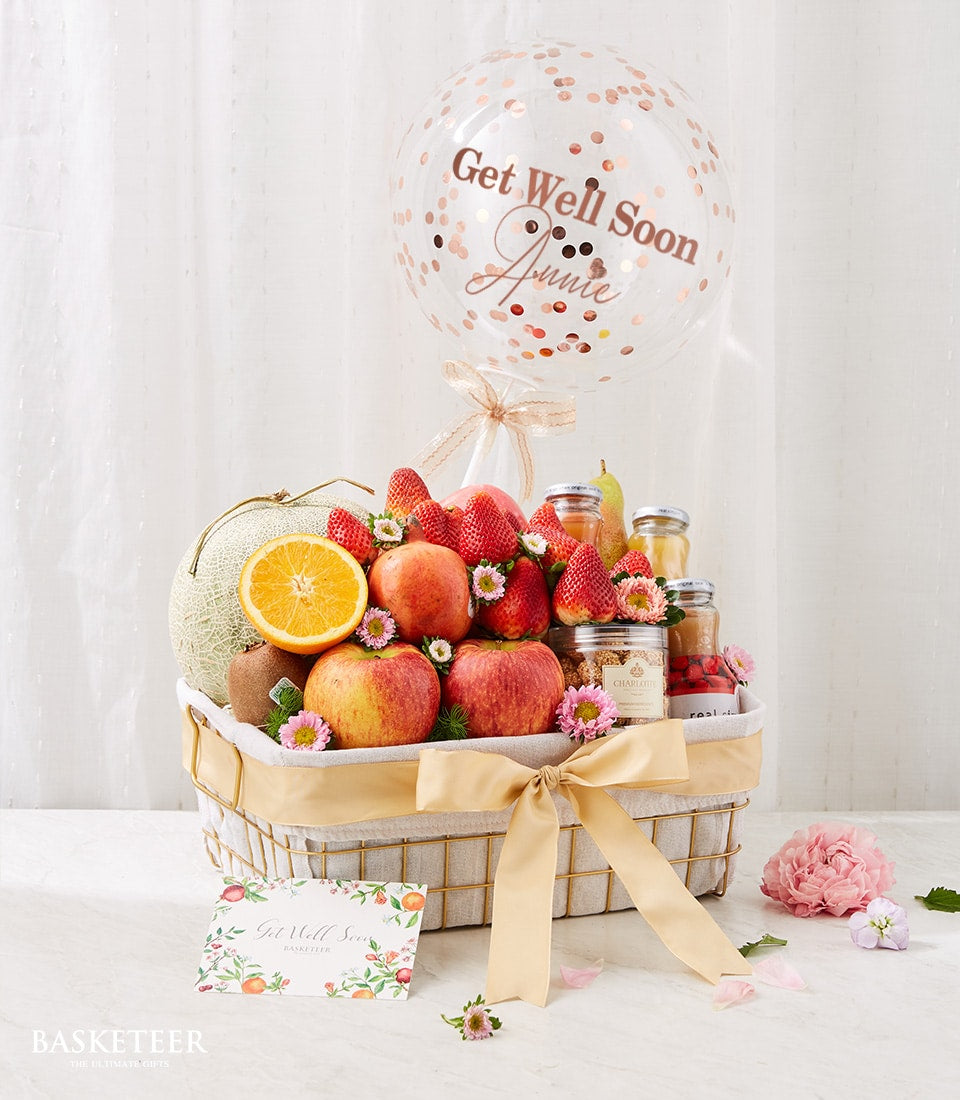 Fresh fruit wellness basket with cantaloupe, apples, strawberries, and peaches, tied with gold ribbon and Get Well Soon