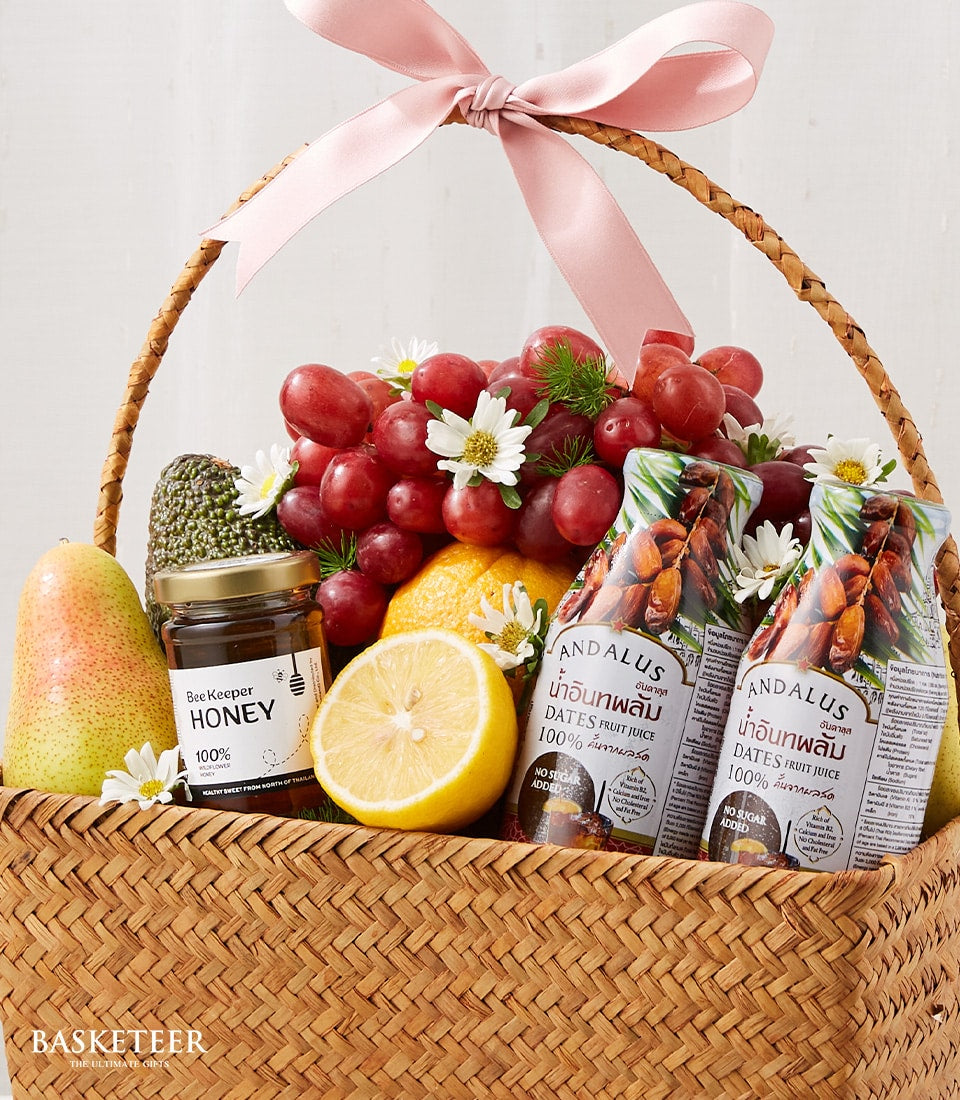Wicker fruit and wellness gift basket with grapes, pear, honey, and date juice for get well recovery