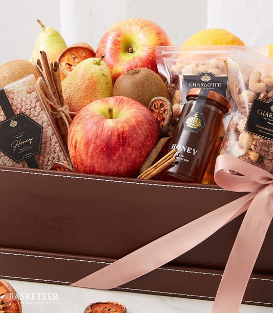 Luxury get well gift basket with fresh apples, pears, kiwis, orange, honey, nuts, and dried fruit in brown leather with pink