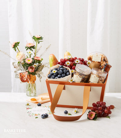 Recovery fruit and flower basket with fresh grapes, pears, blueberries, nuts, and pink-white blooms for get well wishes