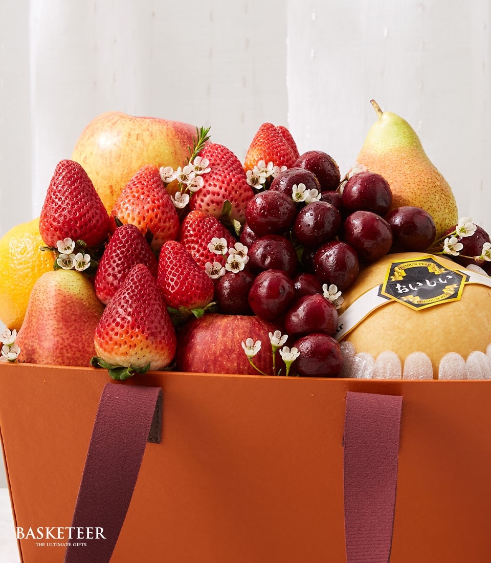 Premium fresh fruit gift basket with strawberries, cherries, apples, and pears in woven container