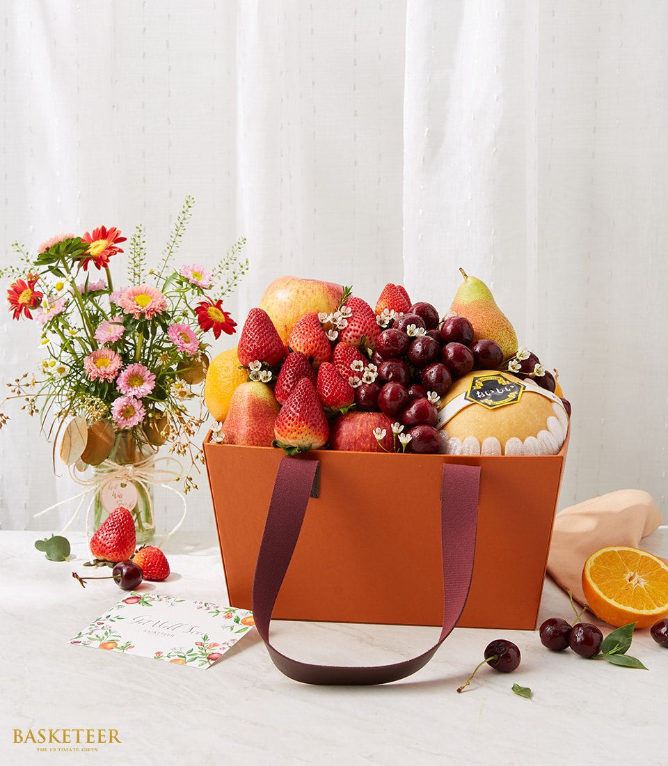 Get well fruit basket with fresh apples, pears, strawberries and pink daisies in gift bag