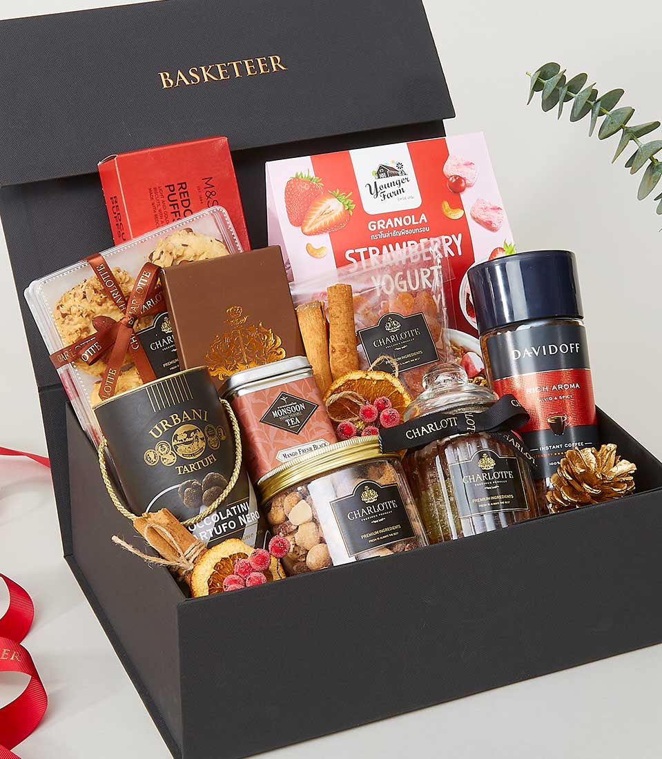 Luxury gourmet gift box with premium chocolates, tea, coffee, granola, and artisan treats for New Year