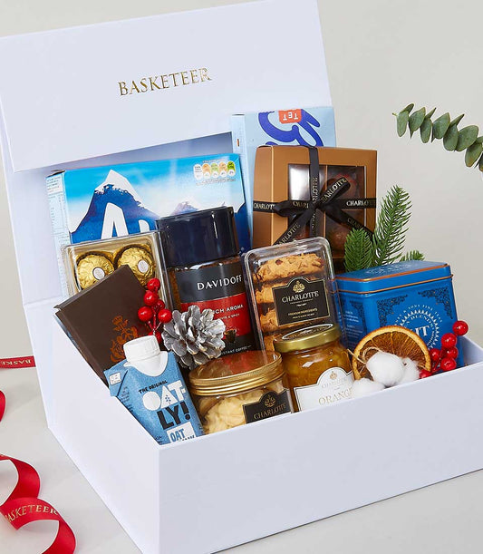 Luxurious white gift box filled with gourmet treats, coffee, cookies, and festive decorations for New Year gifting