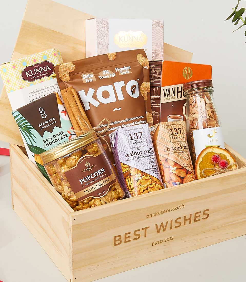 Premium wellness gift box with coconut cashews, dark chocolate, peanut butter popcorn, plant-based milk, and dried fruits in