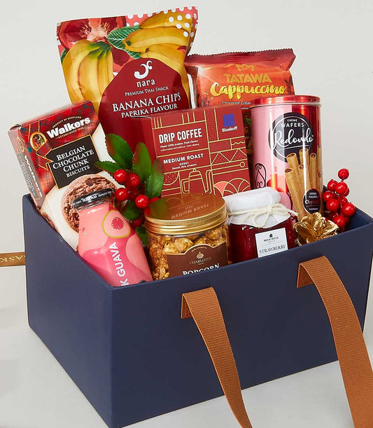 Navy blue leather-handled gift box with gourmet snacks, coffee, jam, and chocolates for New Year gifting