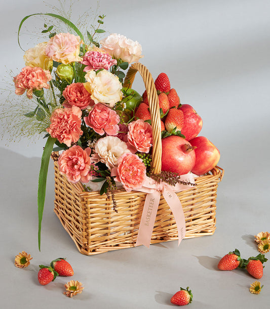 Peach pastel fruit and floral wicker gift basket with pink roses, carnations, strawberries, apples, and pomegranates