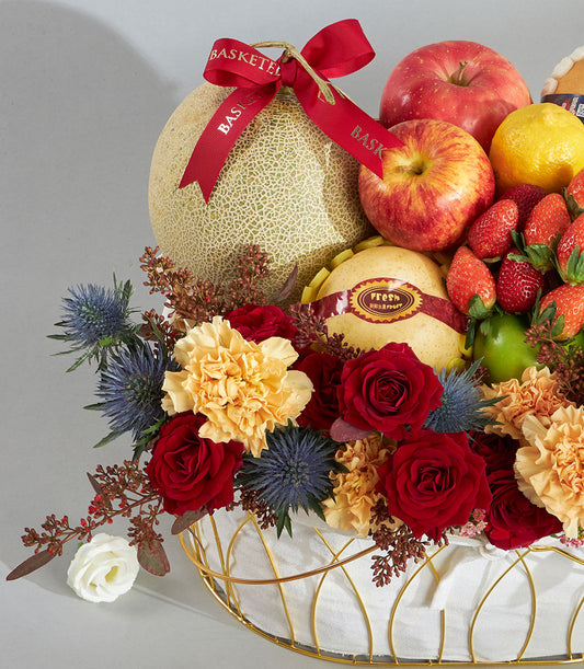 Luxury red and gold fruit floral birthday basket with fresh strawberries, roses, and cantaloupe in woven gold wire base