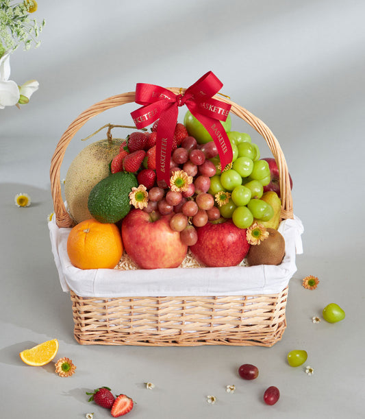 Premium mixed imported fruit basket with wicker weave, red ribbon bow, and fresh tropical fruits