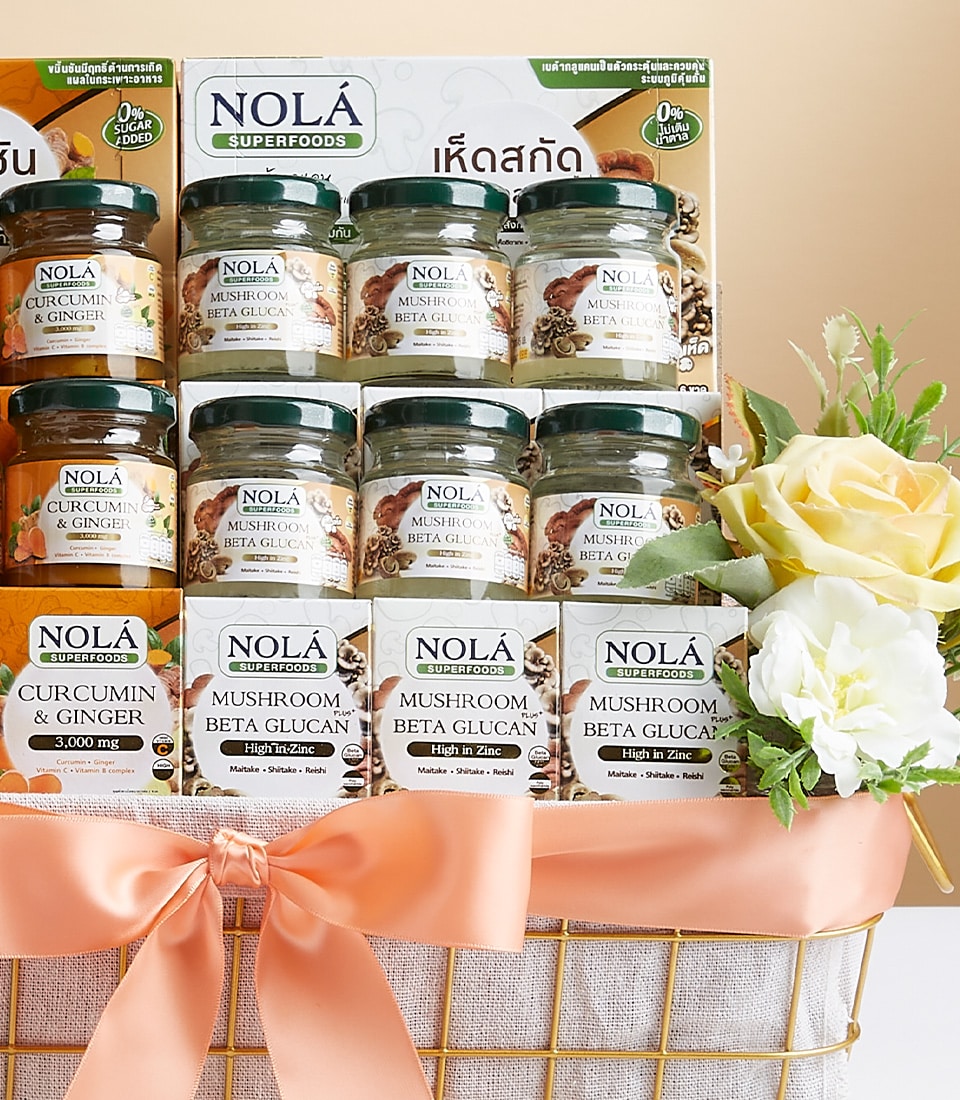 Nola's Fusion wellness gift basket with mushroom beta glucan and curcumin supplements in gold wire basket, peach ribbon bow