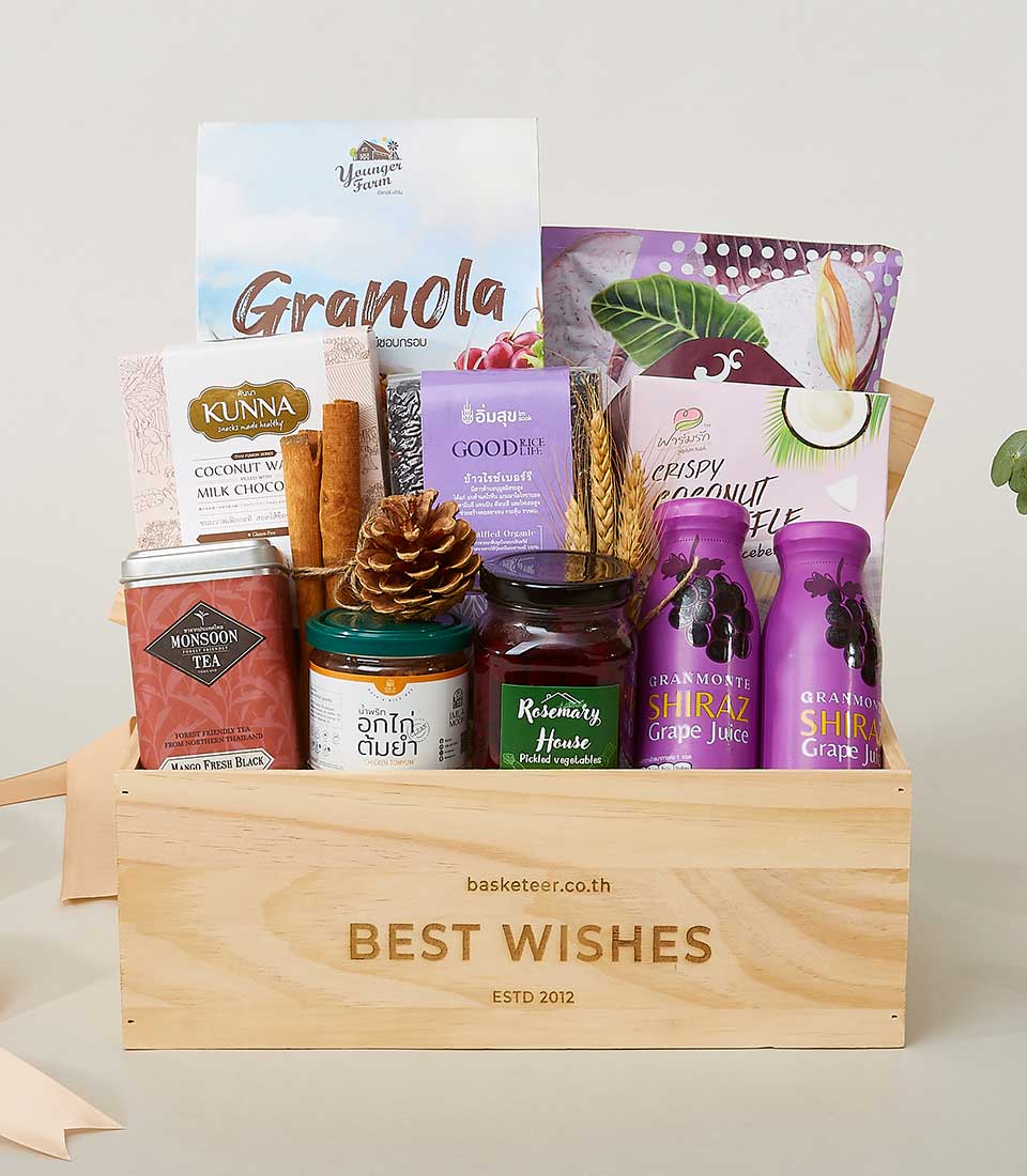Wooden gift box filled with granola, coconut wafers, gourmet tea, pickled vegetables, and grape juice for New Year wellness