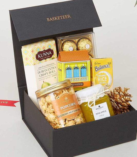 Luxury black gift box with gourmet food pairings including durian roll, chocolates, popcorn, and pineapple preserve for New