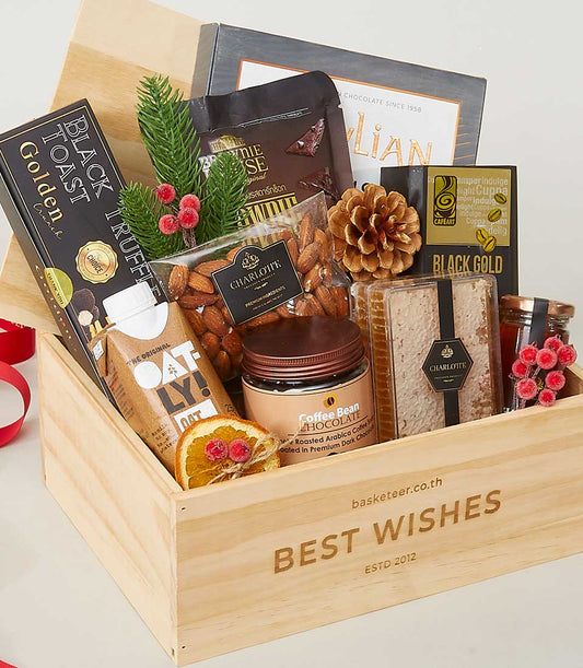Wooden gift crate filled with gourmet snacks, truffle crackers, oat milk, almonds, and artisan chocolates for New Year