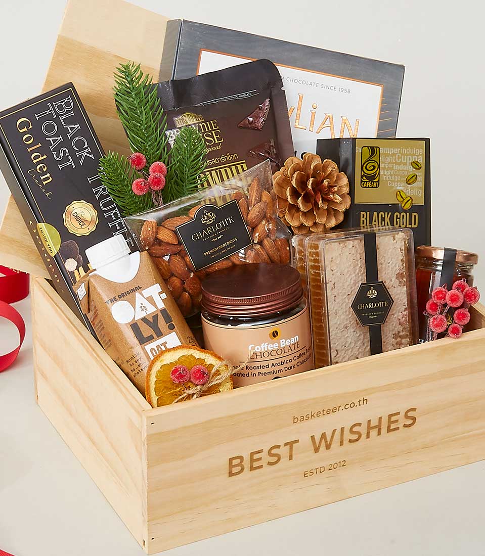 Wooden gift crate filled with gourmet snacks, truffle crackers, oat milk, almonds, and artisan chocolates for New Year