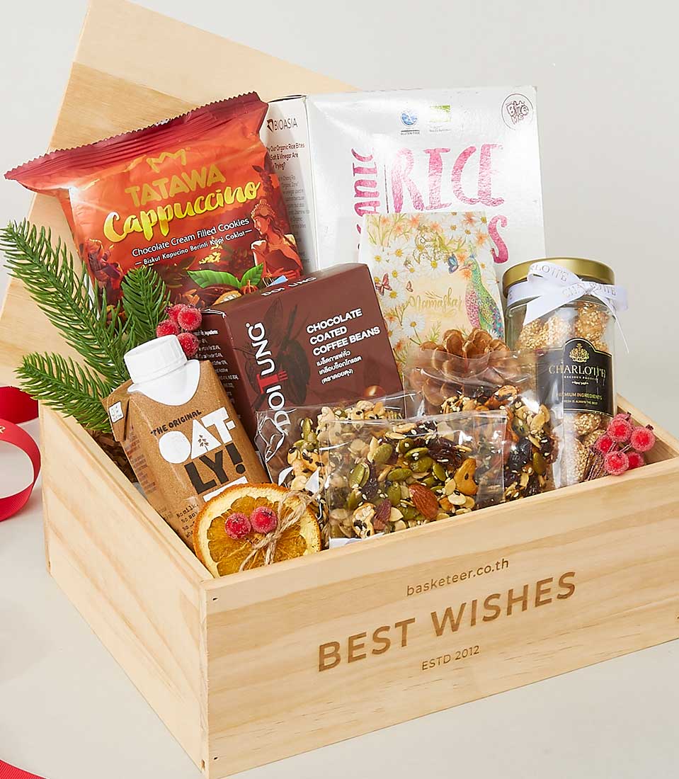 Wooden gourmet gift box with cappuccino cookies, oat milk, coffee beans, nuts, and seasonal evergreen for New Year