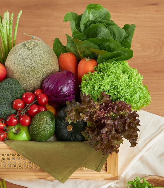 Fresh vegetable and fruit crate with carrots, broccoli, tomatoes, and leafy greens in wooden basket