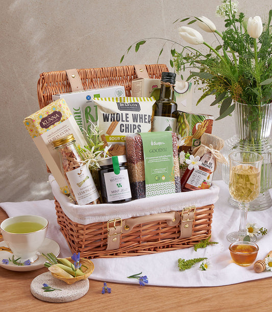 Premium wellness gift basket with olive oil, honey, whole wheat chips, and artisan gourmet snacks in woven wicker