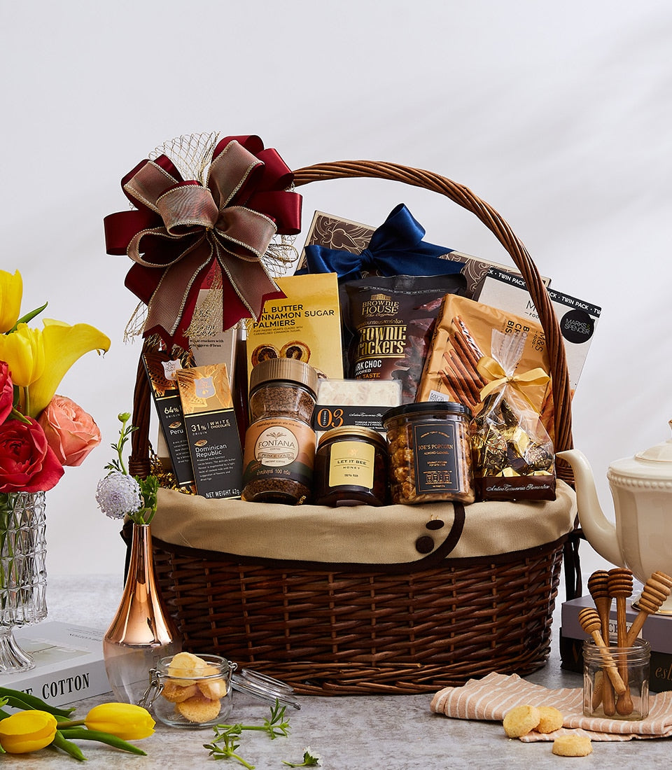 Luxury wicker gift basket filled with gourmet chocolates, coffee, and artisan treats, burgundy gold ribbon, New Year gifting