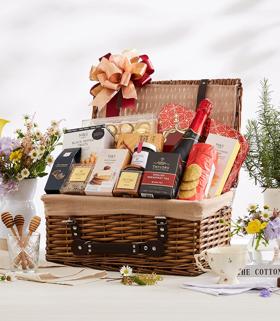 Luxury wicker hamper with gourmet foods, champagne, and gold ribbon bow for premium gifting