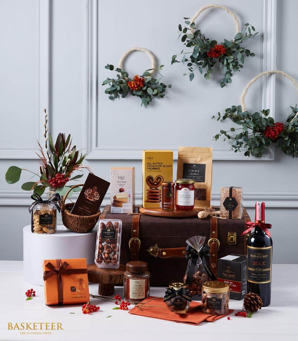 Premium wine and gourmet hamper in leather trunk with red wine, artisan biscuits, honey, and chocolate