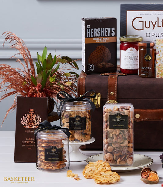 Luxury gourmet gift hamper with dark leather trunk, Belgian chocolate, honey spreads, and Charlotte Bakery baked goods