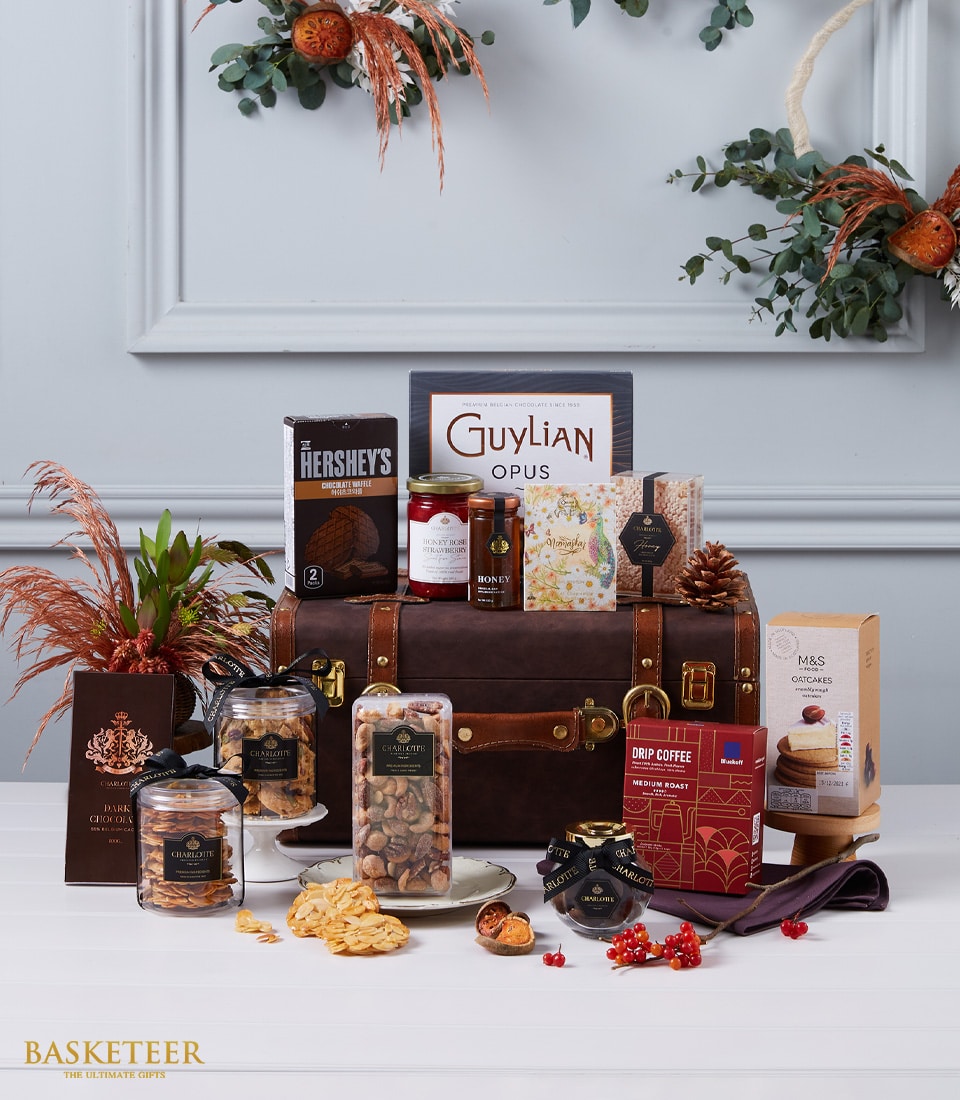 Luxury gourmet hamper with Belgian chocolate, honey spreads, nuts, and premium treats in dark brown leather trunk with brass
