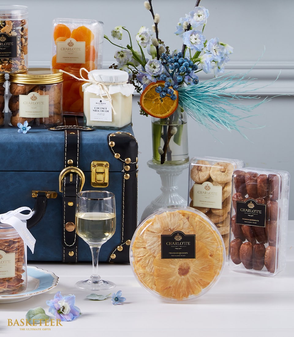Luxury gourmet hamper with dried fruits, nuts, coconut cream, and fresh flowers with blue and white blooms