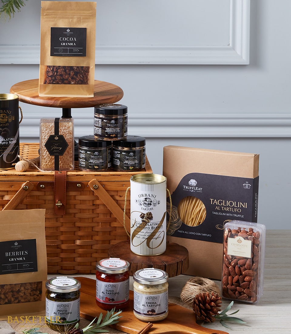 Luxury gourmet hamper with woven basket, truffle pasta, honey jars, and artisan chocolates in kraft packaging