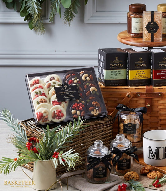 Luxury gourmet hamper with artisan chocolates, premium teas, honey, coffee, and festive décor in wicker basket