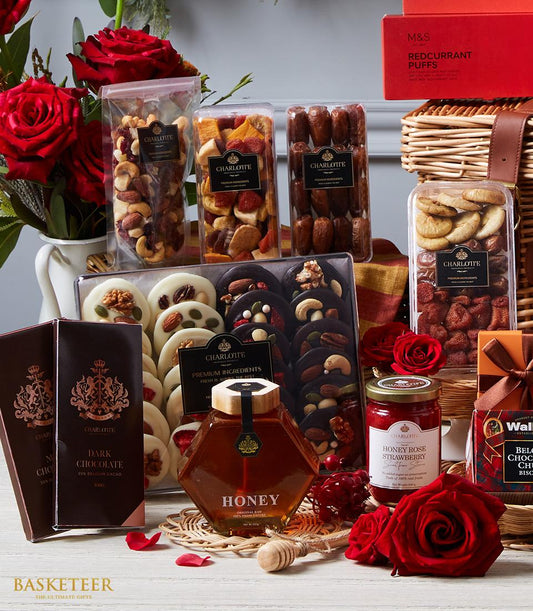 Luxury gourmet gift hamper with imported nuts, dried fruits, chocolates, honey, and fresh red roses