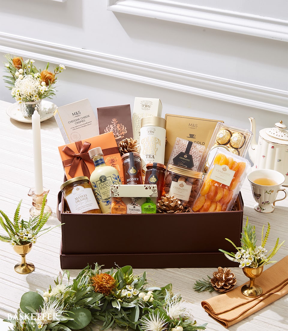 Luxury gourmet gift basket with chocolates, dried fruits, nuts, honey, preserves, and artisan crackers in dark brown