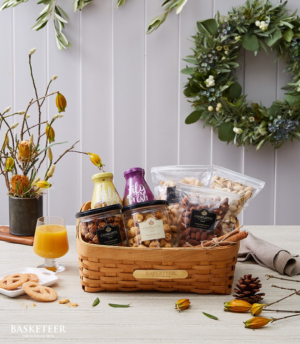 Woven gift basket with granola jars, mixed nuts, dried fruits, wellness bottles and pretzel cookies for New Year