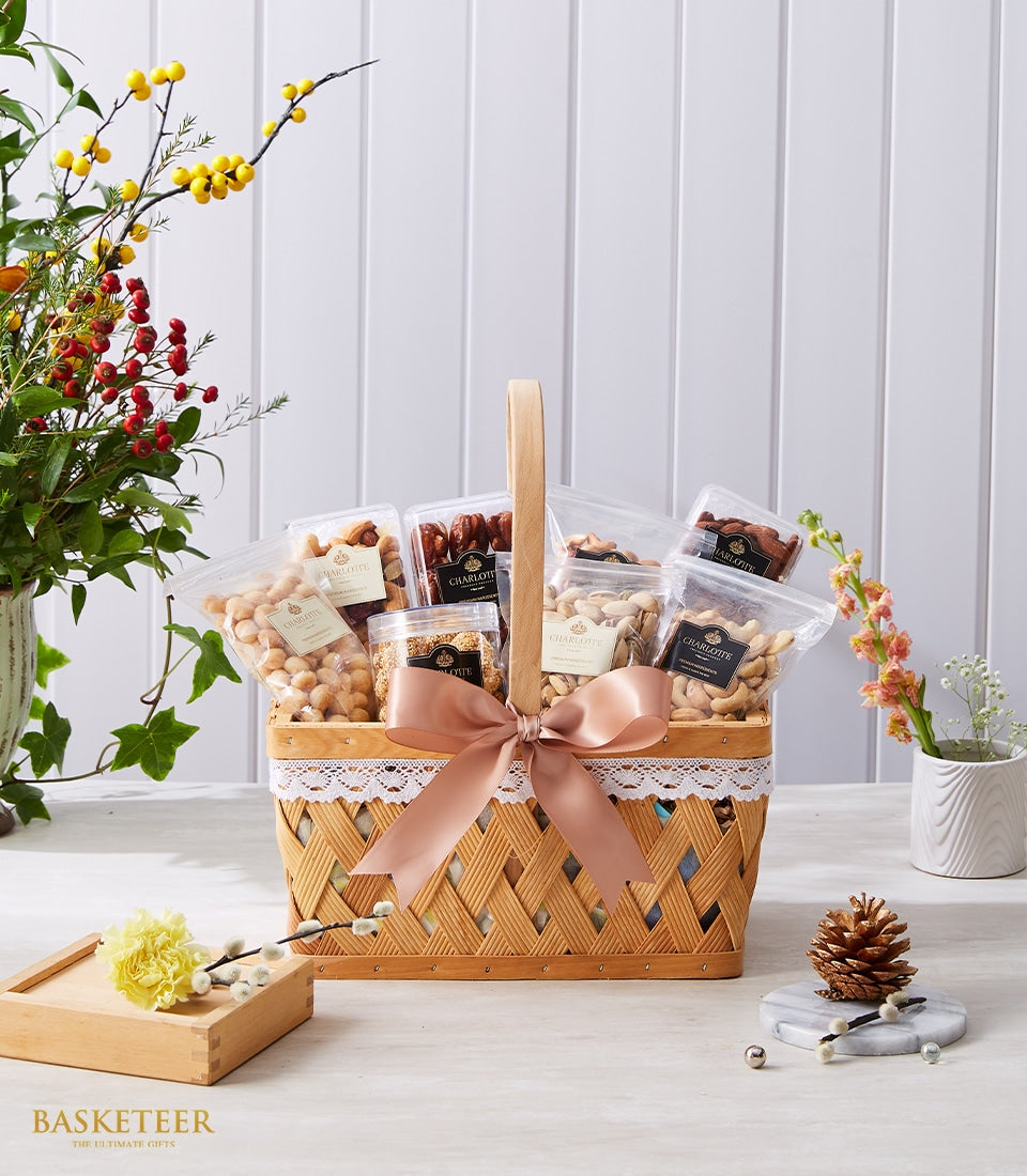 Woven basket filled with premium nuts and dried fruits, tied with peach satin ribbon and ivory lace trim