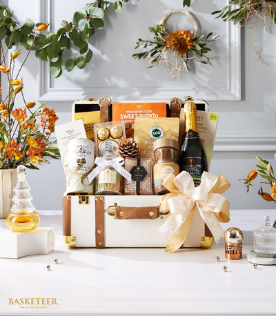 Luxury gift hamper in white faux leather trunk with gourmet coffee, tea, crackers, chocolates, and sparkling wine