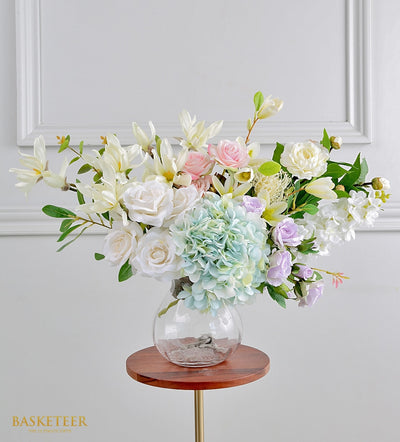Radiant artificial flower arrangement with white roses, pink blooms, and mint hydrangea in clear glass vase