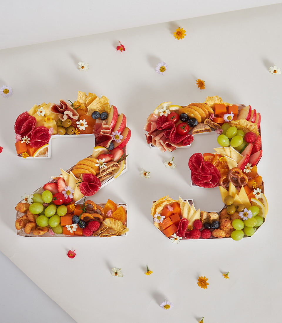 Number-shaped charcuterie boards with cheese, cured meats, fresh berries, and artisan crackers for milestone birthdays
