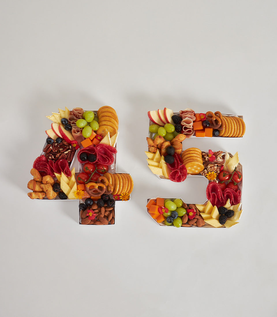 Artisan charcuterie number boards with gourmet cheeses, cured meats, fresh fruits and crackers for birthdays