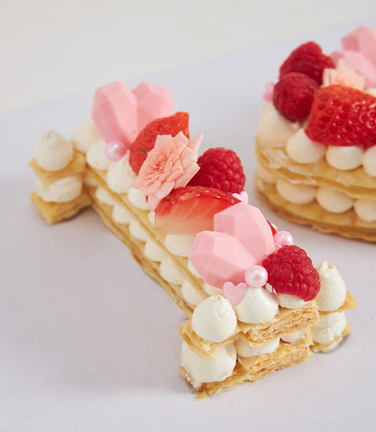 Cream tart number "1" cake with fresh strawberries, raspberries, and pink chocolate hearts