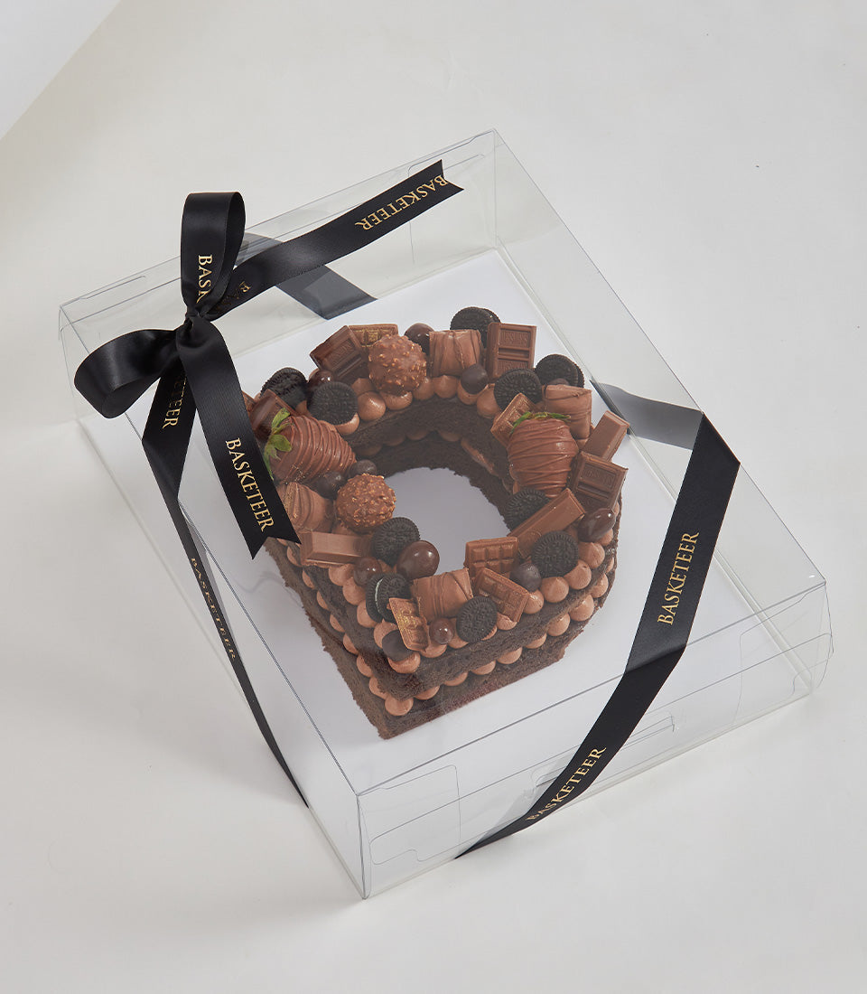 Chocolate letter O cake with strawberries, truffles, and candy toppers in luxury gift box with Basketeer ribbon