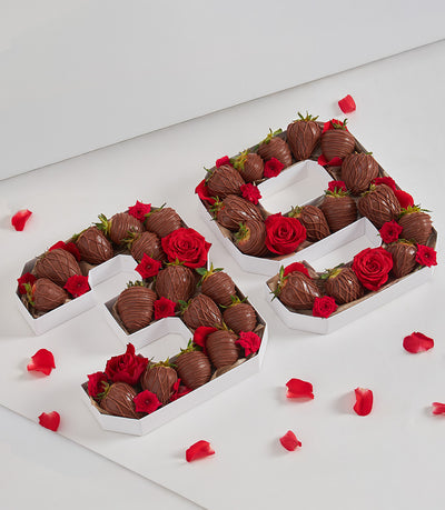 Chocolate-covered strawberries and red roses in white number-shaped gift boxes for birthdays