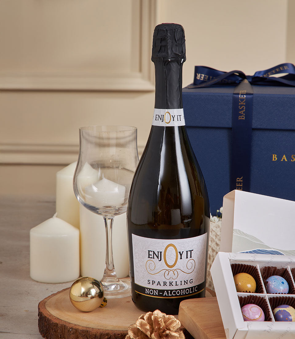 Sparkling celebration gift set with non-alcoholic wine, gourmet chocolates, and festive candle accents for New Year