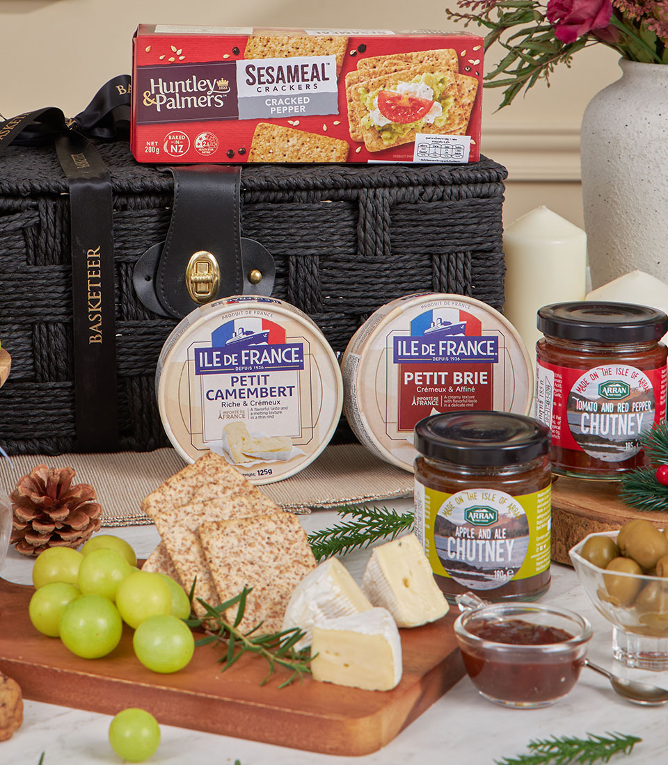 Luxury black woven basket with imported French cheeses, gourmet crackers, artisan chutneys, and fresh grapes gift hamper