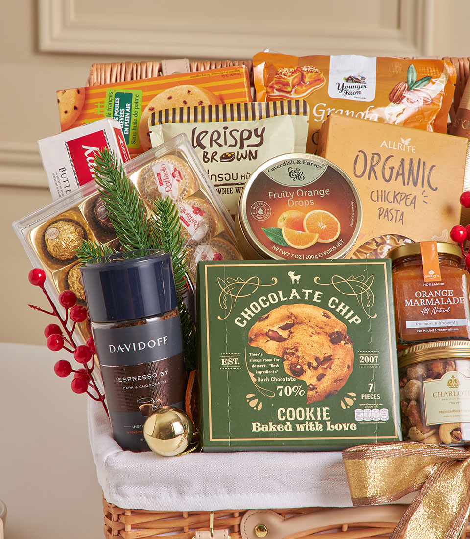Woven wicker gourmet hamper with artisan chocolates, espresso, cookies, and festive gold ribbon for New Year gifting