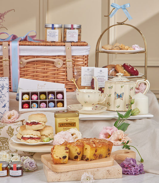 Luxury afternoon tea hamper with wicker basket, British shortbread, chocolates, scones, Earl Grey tea, and fresh flowers